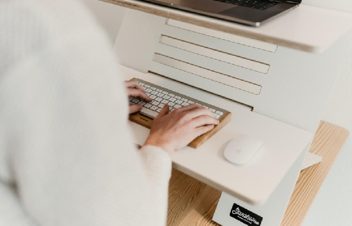 An individual working on a laptop at a desk, exploring the cost-effectiveness of digital fax solutions.